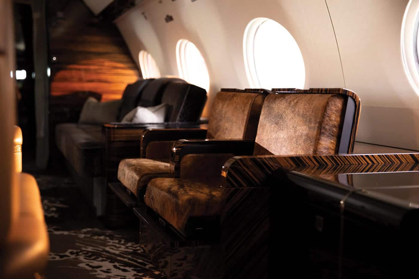 LXi Cabin Collection, Gulfstream G650, Ultra Long Range, Cosmos Interior, Flexjet, seating view, leather seating, jet interior, private jet, jet cabin, cabin interior, cabin view, addtional seating, ottoman, zebra wood